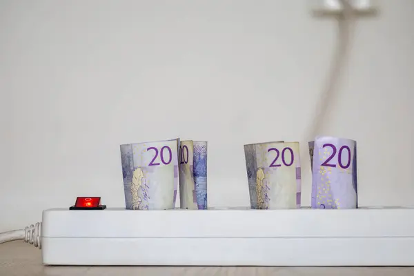 stock image An electricity extension cord and socket with Swedish 20 kronor notes.