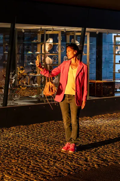 Stock image Stockholm, Sweden Aug 16, 2024 A woman takes a selfie in the Slussen district in the warm setting sun.