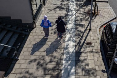 Stockholm, Sweden Aug. 24, 2024 Two women walking down the street in the Rinkeby suburb. clipart