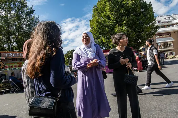 Stock image Stockholm, Sweden Aug. 24, 2024 Women speaking  at the outdoor summer Rinkeby festival in the Rinkeby suburb with food trucks..