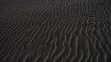 Ocean City, Maryland, ABD Geceleri sahilde yürüyen bir adam ayak izleri bırakıyor. 