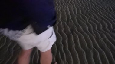 Ocean City, Maryland, ABD Geceleri sahilde yürüyen bir adam ayak izleri bırakıyor. 