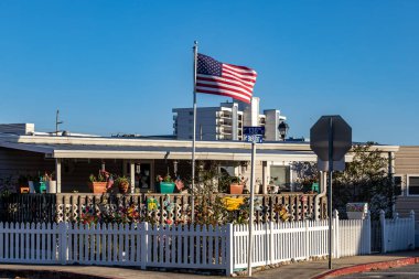 Ocean City, Maryland, ABD 3 Eylül 2024 Amerikan bayrağı ve beyaz çitli küçük bir ev.