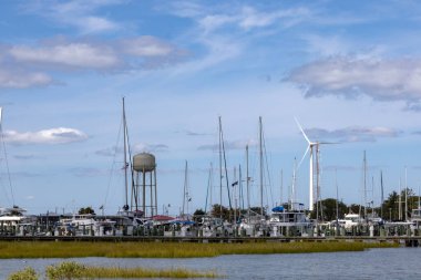 Crisfield, Maryland, ABD 4 Eylül 2024 Limanın tekneleri, su kulesi ve rüzgar türbini manzarası.