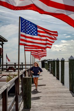 Crisfield, Maryland, ABD 4 Eylül 2024 Bir kadın Amerikan bayraklarıyla kentte balıkçılık yapıyor.