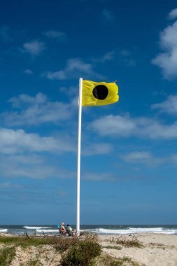 Assateague Beach, Virginia, USA Sept. 5 2024 People on the windy Atlantic Ocean Assateague Island National Seashore beach in the summer, and safety flag. clipart