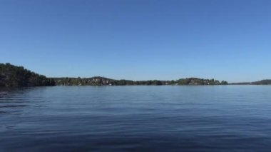 Stockholm, İsveç 'te bir motorlu tekne yaz günü Malaren Gölü' nün mavi durgun sularında süzülür.. 