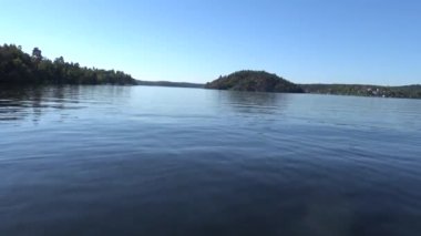 Stockholm, İsveç 'te bir motorlu tekne yaz günü Malaren Gölü' nün mavi durgun sularında süzülür.. 