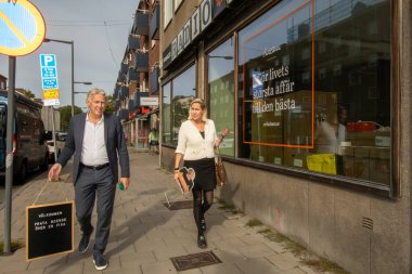 Stockholm, İsveç 18 Eylül 2024 Vastertorp banliyösünde yürüyen bir kadın ve erkek emlakçı..