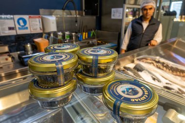 Baku, Azerbaijan Sept 22, 2024 Local Caspain Sea caviar for sale in the  Bazar food market and a shop attendent. clipart