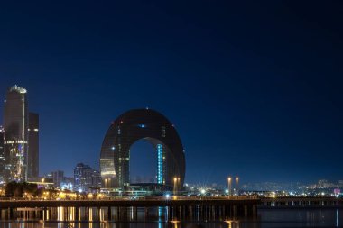 Bakü, Azerbaycan. Hazar Denizi kıyısındaki Crescent Körfezi binasının gece manzarası..