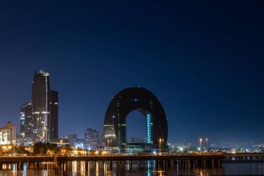 Bakü, Azerbaycan. Hazar Denizi kıyısındaki Crescent Körfezi binasının gece manzarası..