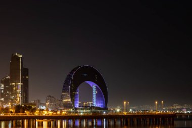 Bakü, Azerbaycan. Hazar Denizi kıyısındaki Crescent Körfezi binasının gece manzarası..