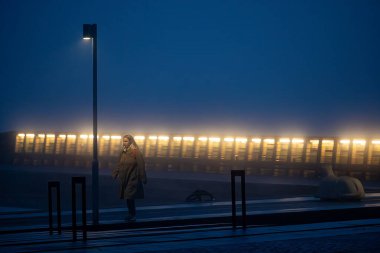 Stockholm, Sweden Oct 6, 2024 A person walking in the Liljeholmskajen neighborgood in the early morning fog. clipart