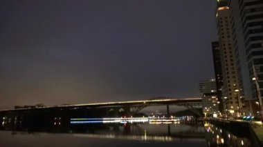 Stockholm, İsveç Liljeholmen ve Sodermalm arasındaki Artsabron yaya ve tren köprüsünün gece görüşü. 