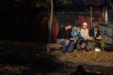 Stockholm, İsveç 12 Ekim 2024 Bir tekne kulübündeki parkta insanlar mevsim için teknelerini kaldırdıktan sonra sonbahar güneşinde mola verirler..