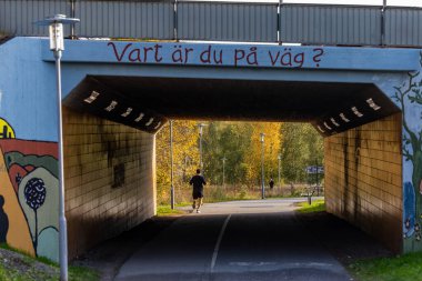 Stockholm, İsveç 19 Ekim 2024 Ursvik bölgesindeki bir yeraltı geçidinde koşucu ve İsveççe 
