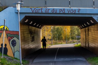 Stockholm, İsveç 19 Ekim 2024 Ursvik bölgesindeki bir yeraltı geçidinde koşucu ve İsveççe 