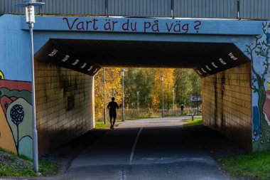 Stockholm, İsveç 19 Ekim 2024 Ursvik bölgesindeki bir yeraltı geçidinde koşucu ve İsveççe 