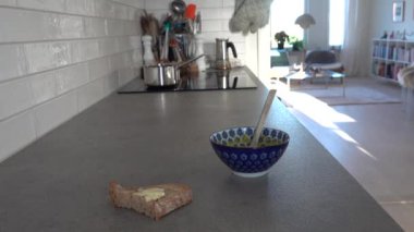 Stockholm, İsveç 'te bir adam mutfak tezgahında çorba içer ve temizlik yapar..