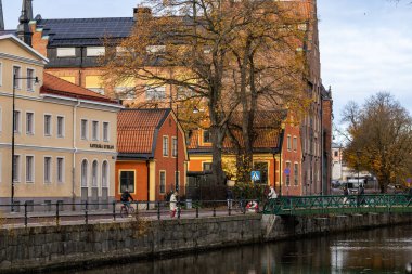 Uppsala, İsveç 28 Ekim 2024 Uppsala Fyrisan Nehri 'nin kenarındaki yayalar.