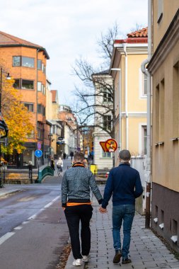 Uppsala, İsveç 28 Ekim 2024 Sokakta yürürken el ele tutuşan iki eşcinsel.