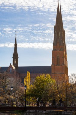 Uppsala, İsveç 28 Ekim 2024 Uppsala Domkyrka ya da Uppsala Katedrali şehrin ufuk çizgisine ve Fyrisan Nehri üzerindeki Demir Köprü 'ye hakim..