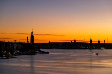 Stockholm, İsveç Sabahın erken saatlerinde bir tekne ve şehrin silueti.