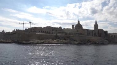 Valletta, Malta Valletta Limanı 'na bir gemi yaklaşımı ve tarihi yapı ve Balo' nun Kalesi ve antik şehir duvarları aydınlandı..