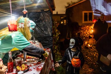 Stockholm, İsveç 31 Ekim 2024 Cadılar Bayramı partisinde Alvsjo bölgesinde kasap gibi giyinmiş korkunç bir çift..