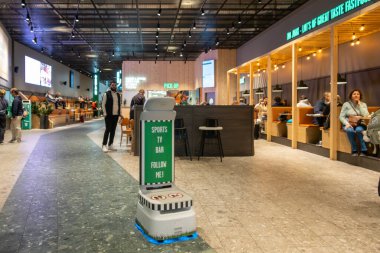 Stockholm, İsveç 1 Kasım 2024 Arlanda Havaalanı 'ndaki bir barda ve restoranda çalışan bir robot şef insanları masalarına oturtuyor..