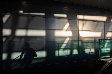 Zürih, İsviçre 1 Kasım 2024 Zürih Havaalanı 'nda yürüyen merdivene binen insanların gölgeleri.