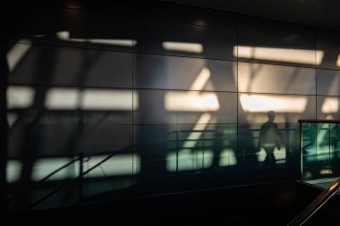 Zürih, İsviçre 1 Kasım 2024 Zürih Havaalanı 'nda yürüyen merdivene binen insanların gölgeleri.