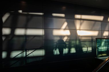 Zürih, İsviçre 1 Kasım 2024 Zürih Havaalanı 'nda yürüyen merdivene binen insanların gölgeleri.