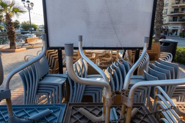 Valletta, Malta 5 Kasım 2024 Sliema bölgesindeki tahta kaldırımda ters dönmüş kafe masaları ve sandalyeler..