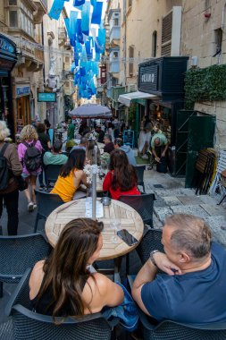 Valletta, Malta No: 7, 2024 Tarihi eski kasabadaki açık hava kafelerinde oturan insanlar.