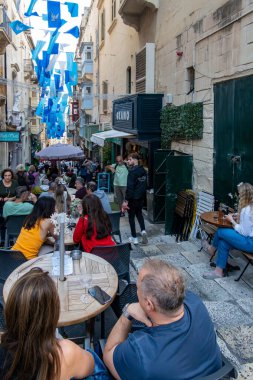Valletta, Malta No: 7, 2024 Tarihi eski kasabadaki açık hava kafelerinde oturan insanlar.