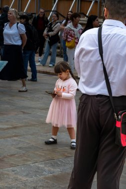 Valletta, Malta No: 7, 2024 Elbiseli hoş bir kız cep telefonunu kontrol ediyor Old Valletta 'da bando bandosu olarak geçiyor..