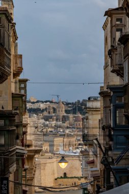 Valletta, Malta Grand Harbour 'daki Fort St. Angelo manzarası Old Valletta' daki dar bir sokaktan..
