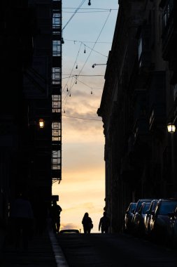 Valletta, Malta 7 Kasım 2024 Eski Valletta 'daki dik ve dar St. Ursula Caddesi' nde insan siluetleri.