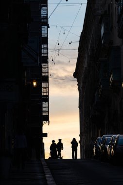 Valletta, Malta 7 Kasım 2024 Eski Valletta 'daki dik ve dar St. Ursula Caddesi' nde insan siluetleri.