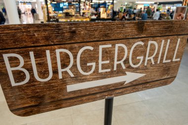 Münih, Almanya 10 Kasım 2024. Uluslararası kalkış terminalindeki bir restoranda hamburger ve ızgara tabelası..