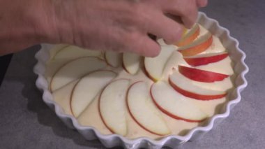 Ev yapımı bir fırıncı ev mutfağında elmalı turta yapar ve pişirmeden önce üzerine tarçın serper.. 