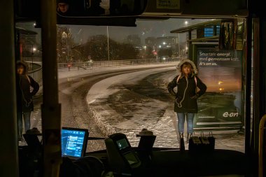 Stockholm, İsveç 21 Kasım 2024. Kış giysileri içinde bir kadın Kungsholmen bölgesindeki otobüs durağında bekliyor..