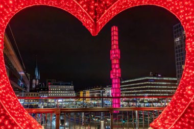 Stockholm, İsveç 29 Kasım 2024. Büyük kırmızı bir kalp ve şehir merkezindeki Sergels Torg manzarası..