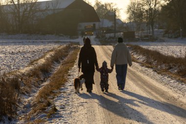 Uppsala, İsveç 7 Aralık 2024 İnsanlar Wik 's Castle' daki geleneksel Noel pazarına doğru karda kırsal bir yolda yürüyor.