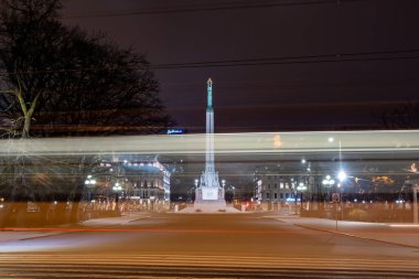 Riga, Letonya 10 Aralık 2024 Eski Şehir 'de gece tramvayı Özgürlük Anıtı' ndan geçer..