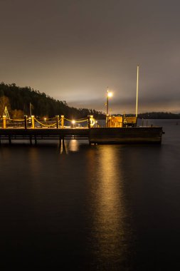 Ekero, Sweden A small dock at night in the moonlight on a dark winter night. clipart