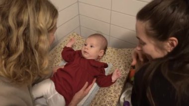 Stockholm, İsveç. Bir büyükanne ve bir anne, evcil bir tuvalette bir kız çocuğuyla soyunma masasında oynuyorlar..  