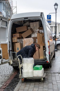 Vilnius, Litvanya 3 Ocak 2025 Genç bir adam kaldırıma mal dolu bir minibüs yüklüyor..